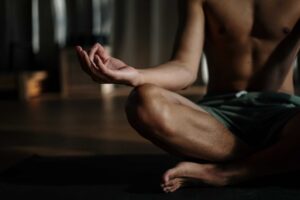 Et billede af en mand der mediterer, hvor man kan se venstre del af kroppen
